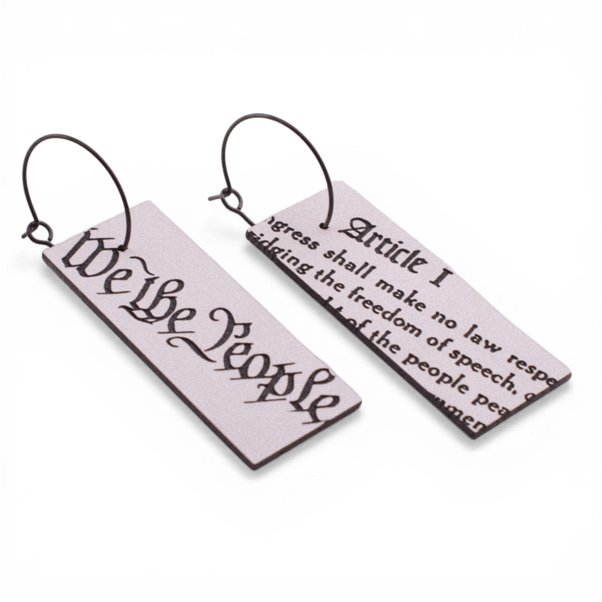 Pair of earrings with words from the Constituion on a white background