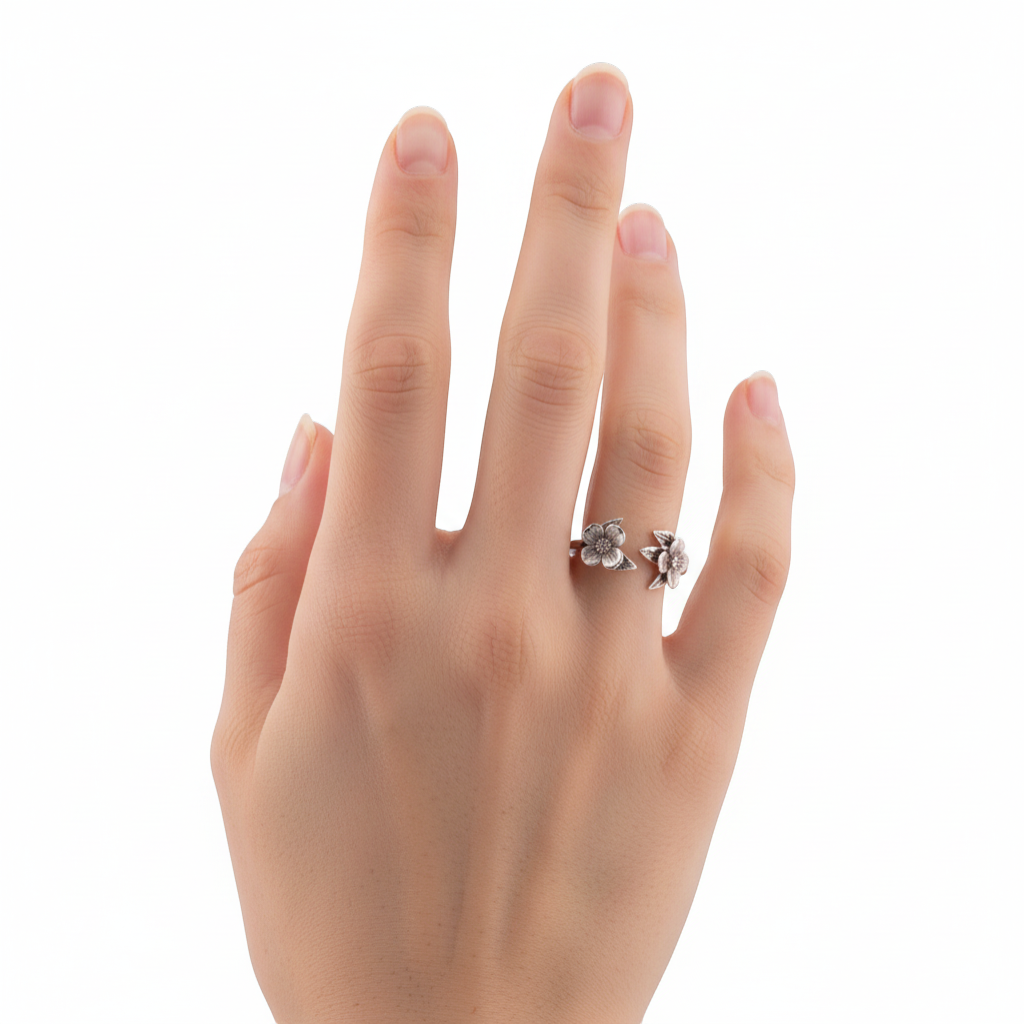 Adjustable sterling silver ring featuring two detailed dogwood blossoms with sculpted leaves, worn on a finger.
