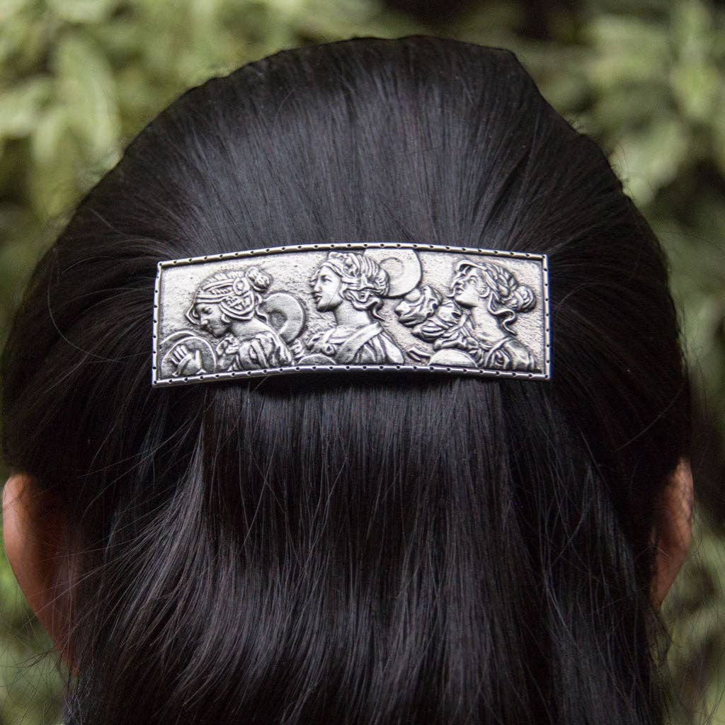 Silver 80mm barrette featuring a hand-cast relief of three women in classical attire, secured in dark hair.