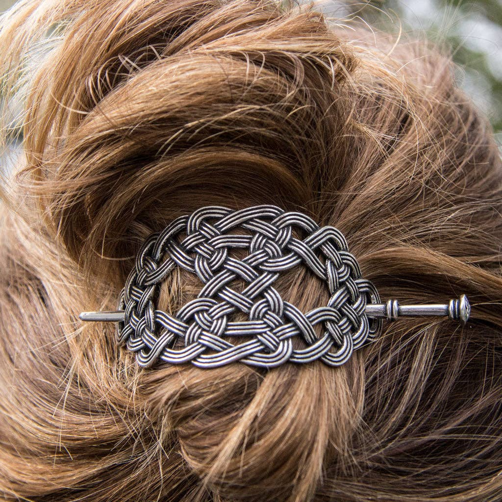 Silver Celtic weave hair stick securing a blonde hair bun, made from Britannia metal.