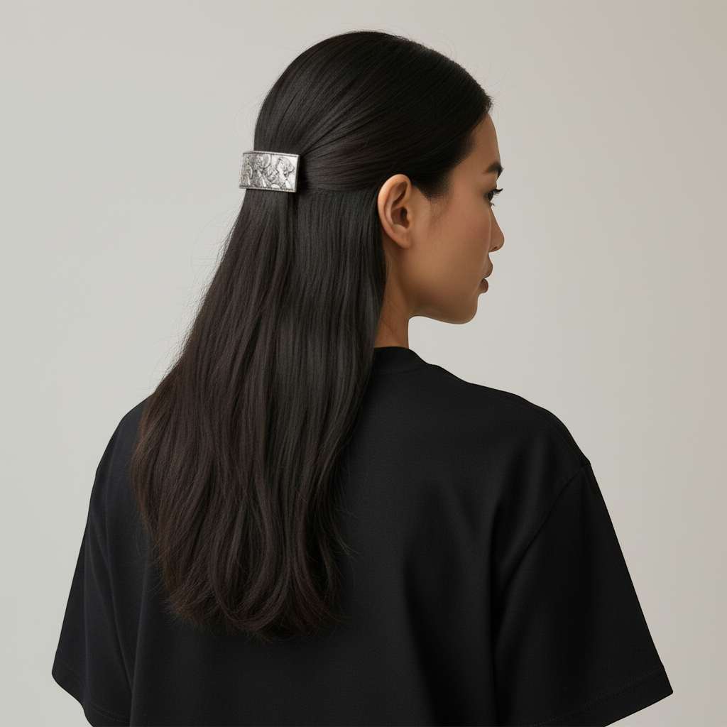 Silver metal barrette hair clip with a detailed embossed scene of figures, 80mm size, worn in dark hair
