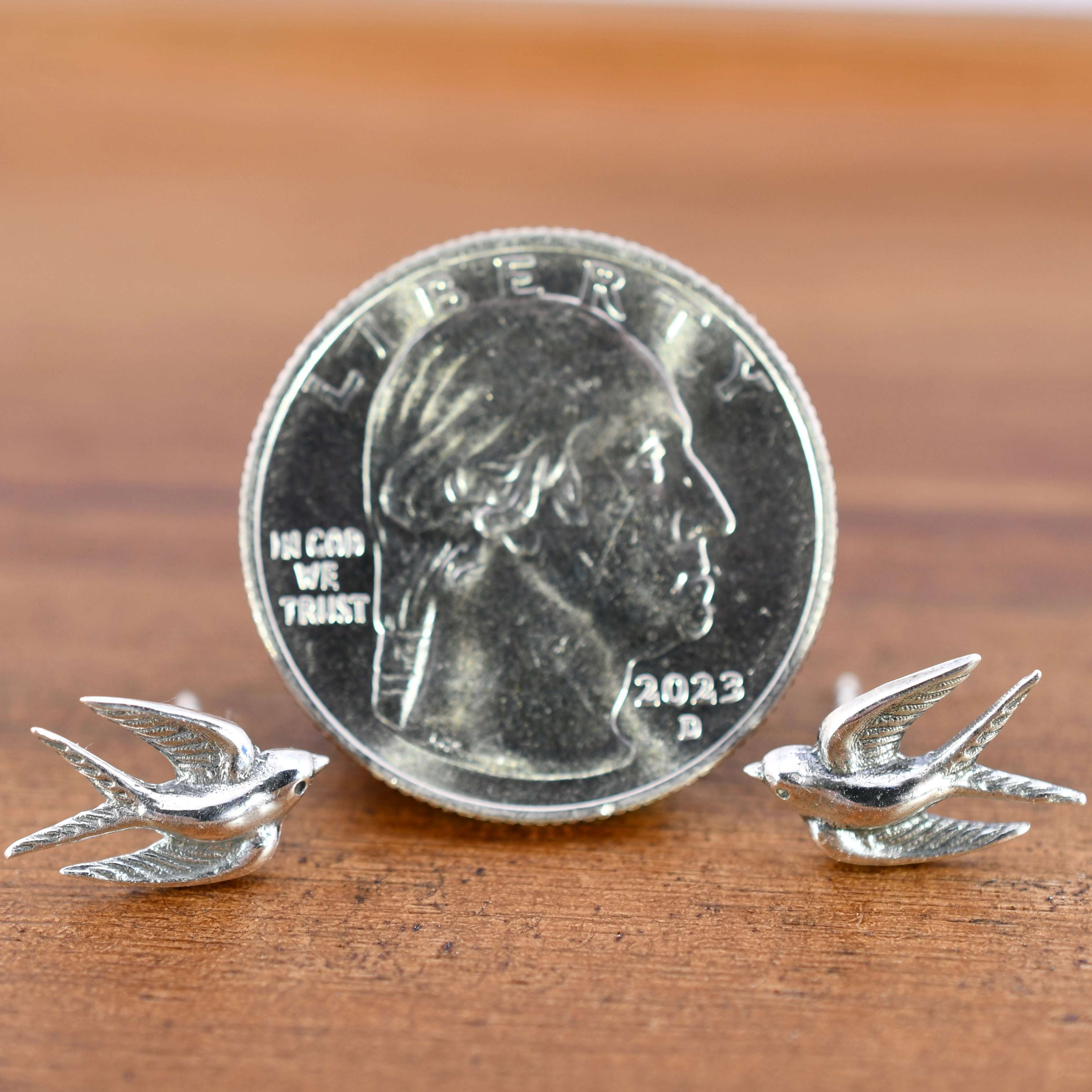 Sterling silver post earrings shaped like swallows in mid-flight, with detailed wings and bodies.
